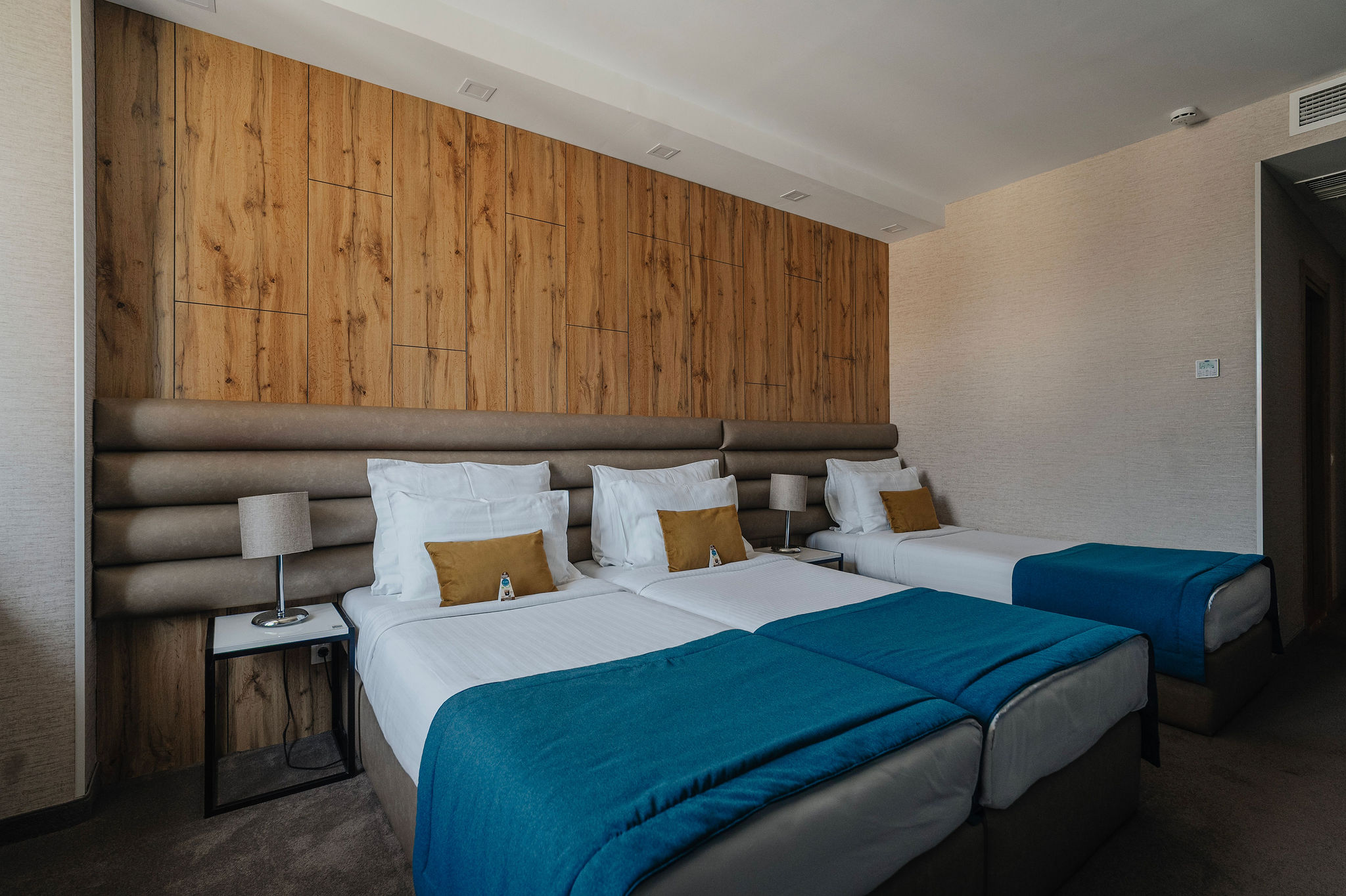 a side view of three hotel room beds