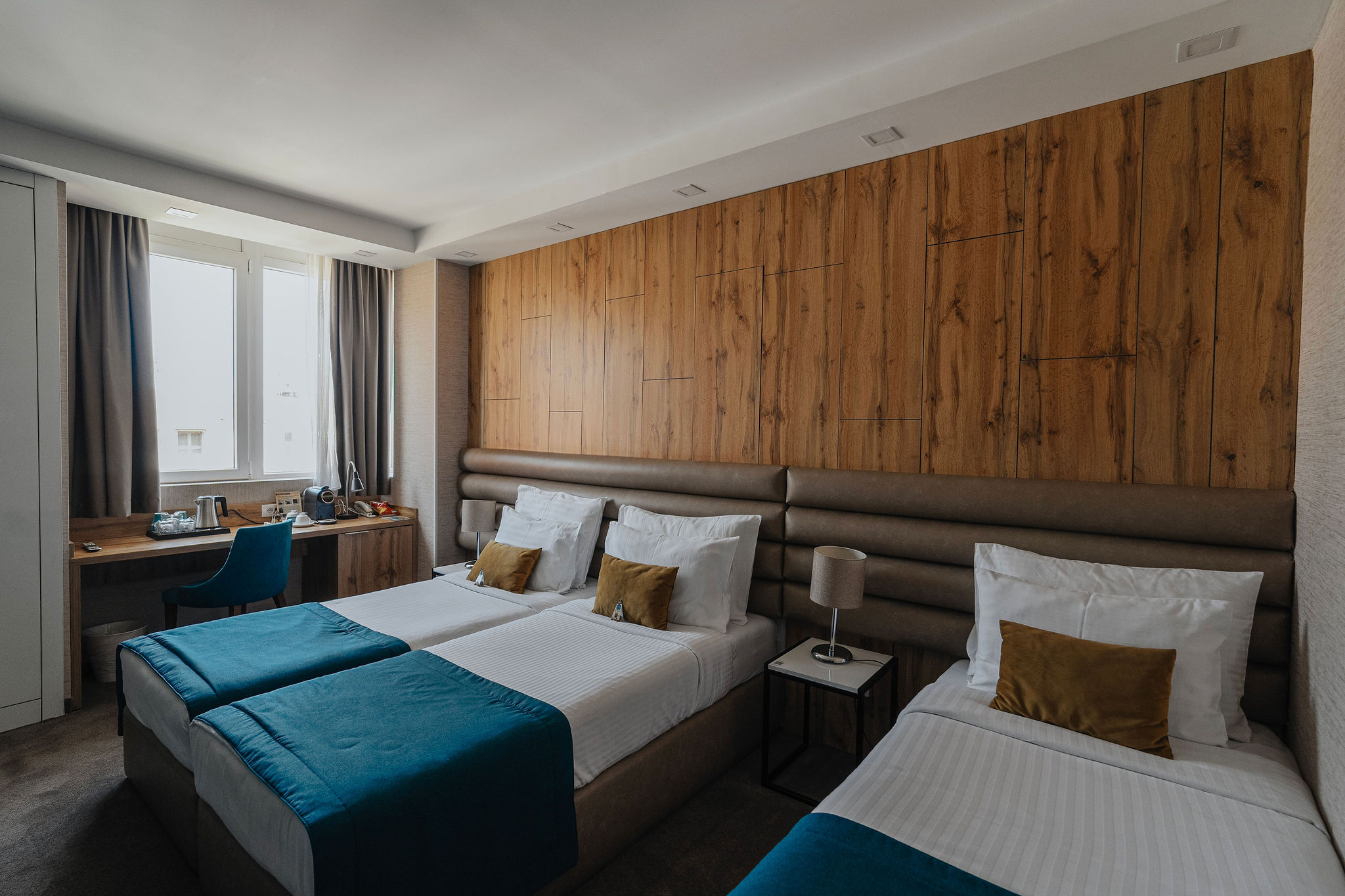 a triple hotel room with a large window