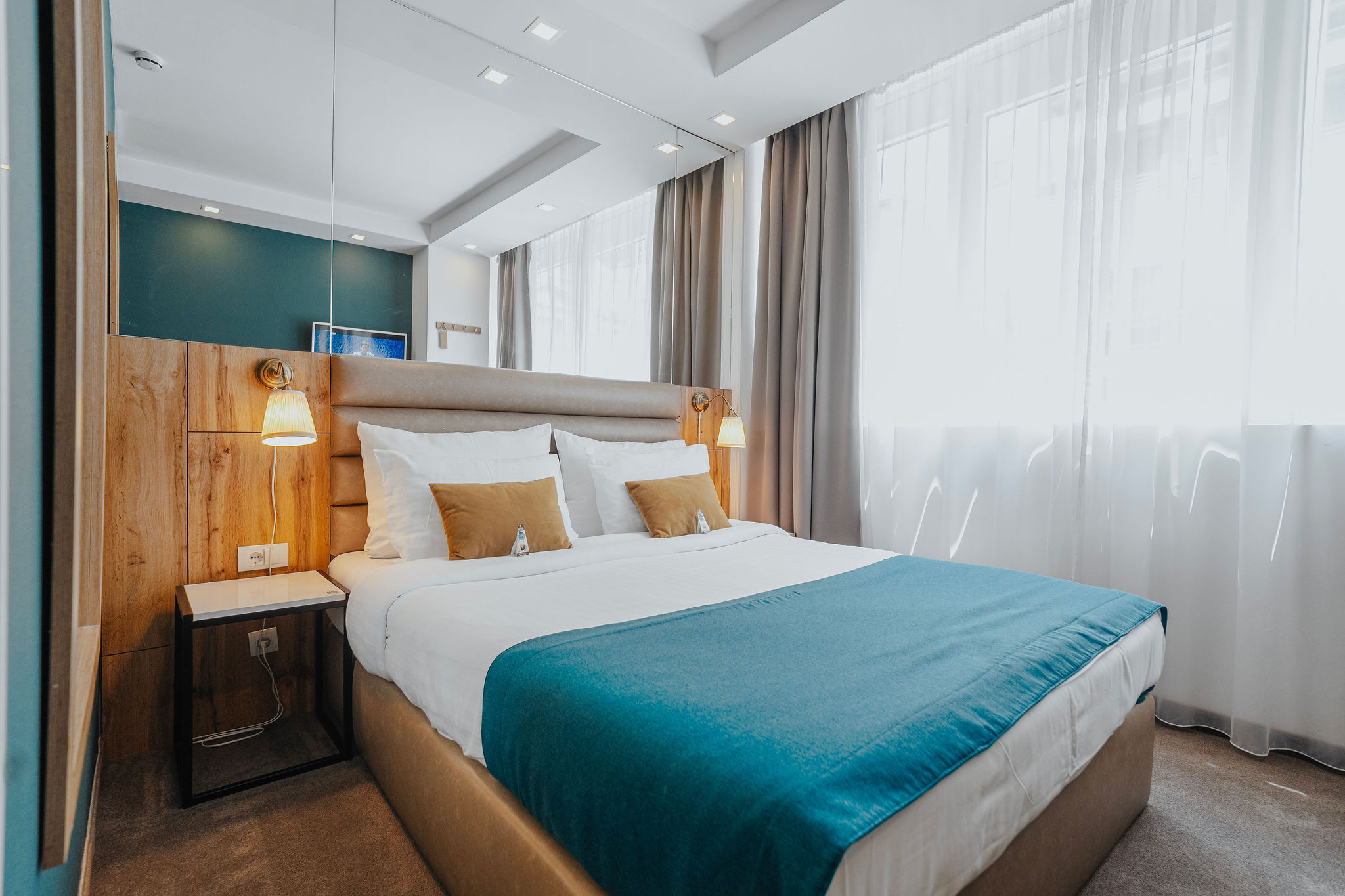 hotel room bed with a mirror behind it