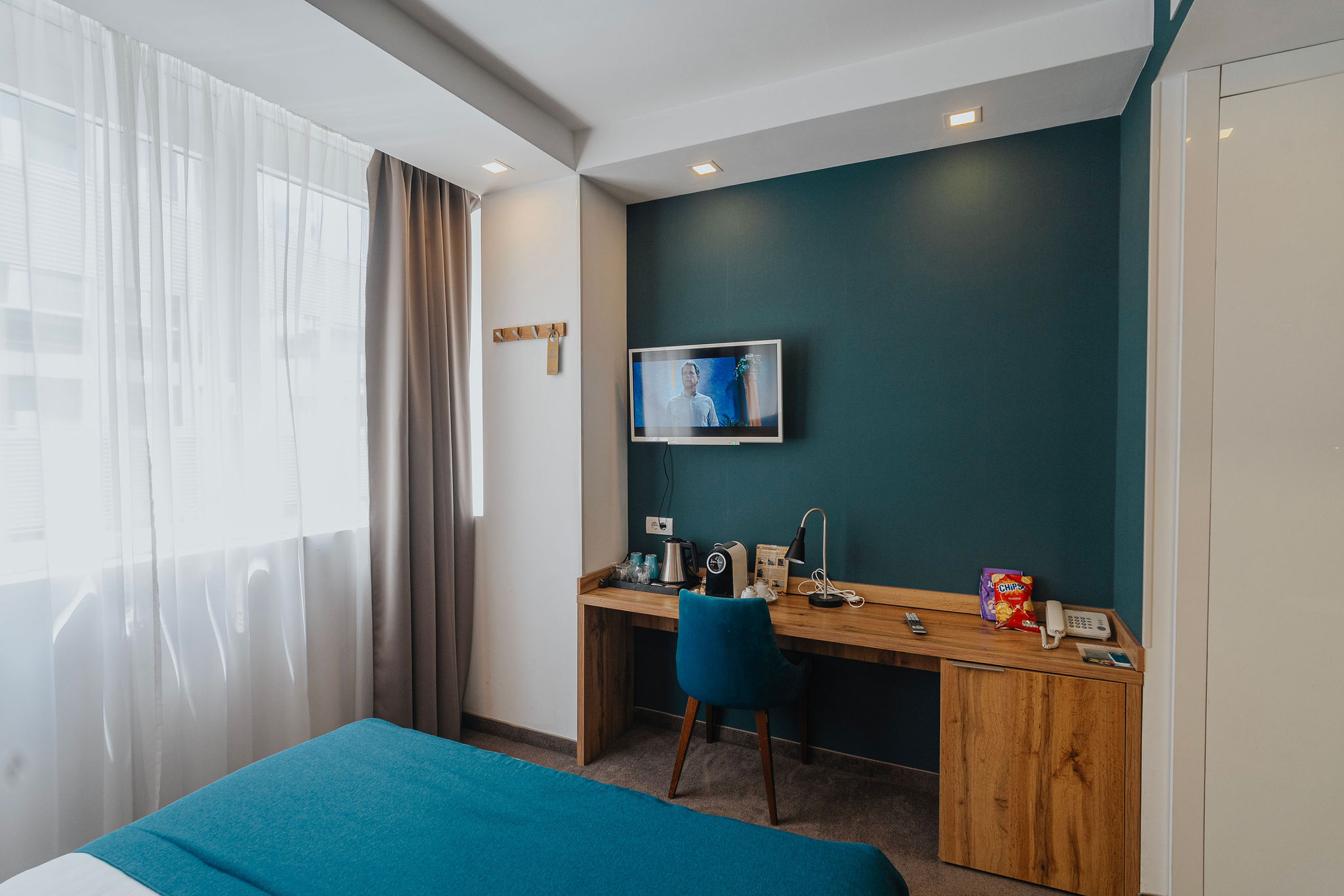 a hotel room tv with a desk under it