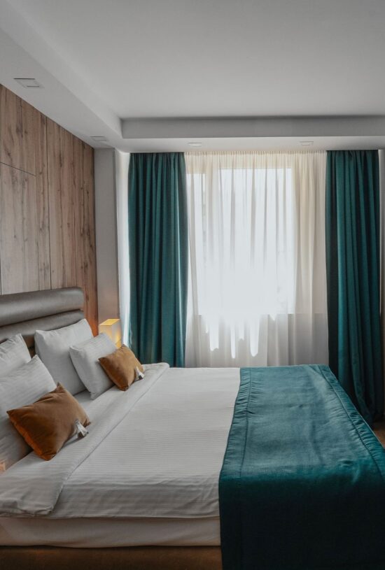 a double bed near a window with curtains